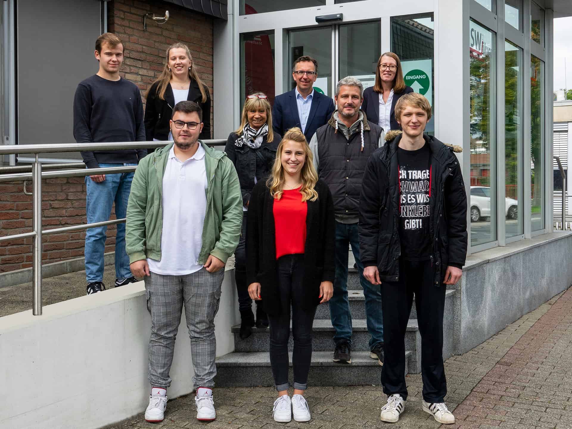 Die neuen Auszubildenden der Stadtwerke Jülich für das Jahr 2022 stehen vor dem Eingang zum Kundenzentrum
