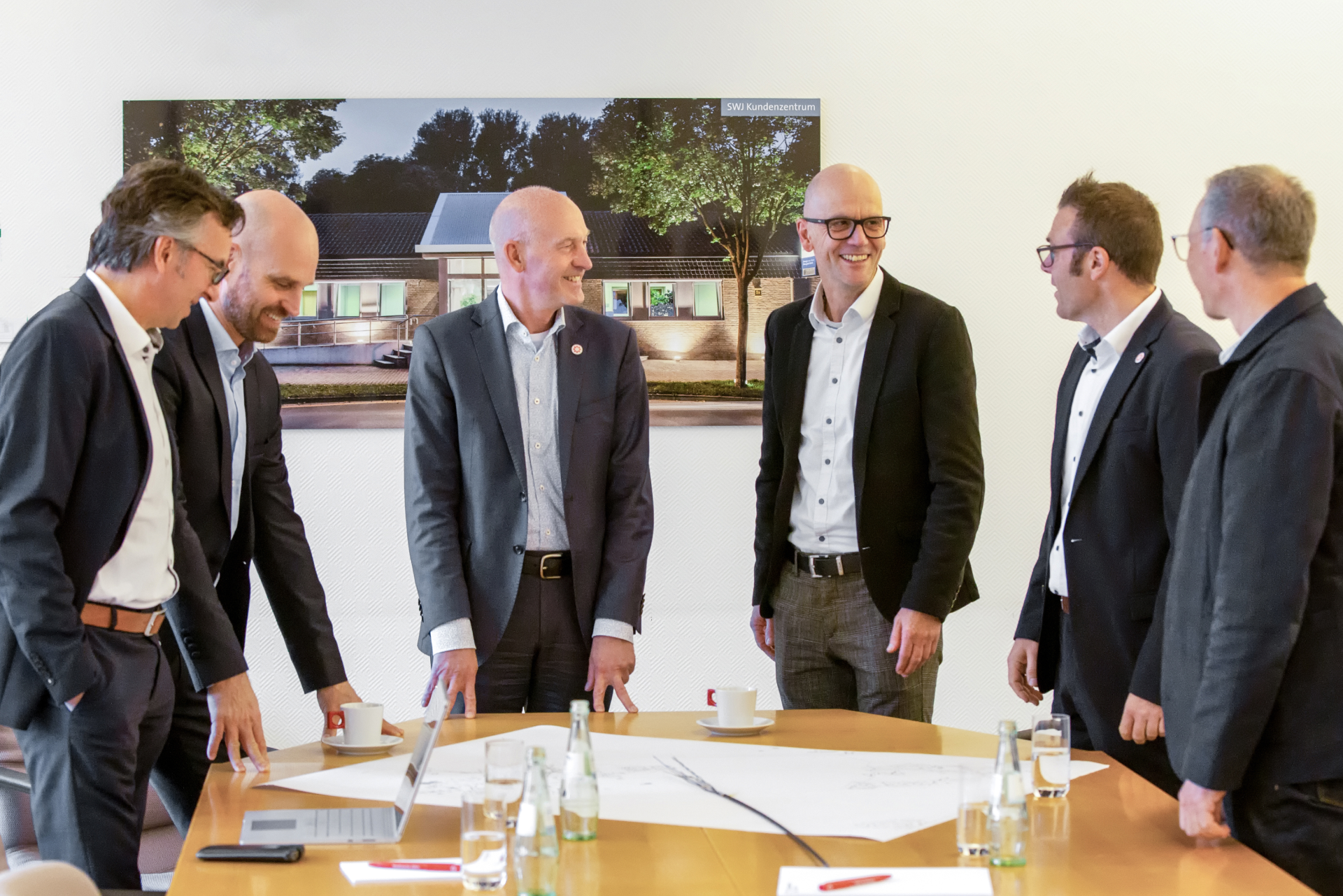 Gruppe von Geschäftspartnern bei einer Besprechung – Symbol für regionale Zusammenarbeit und strategische Partnerschaften.