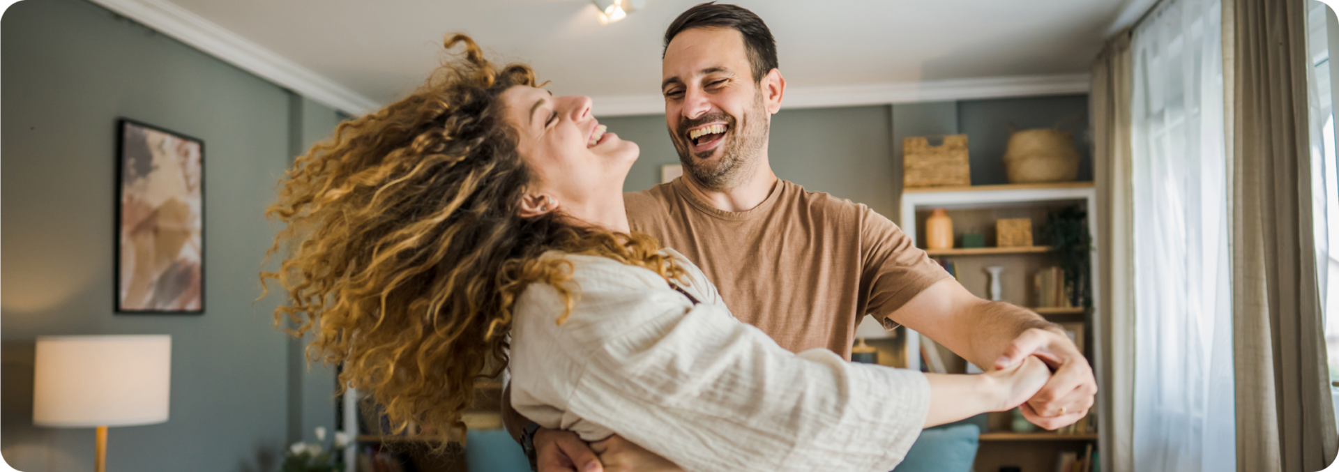 Glückliches Paar tanzt im Wohnzimmer – Symbol für langfristige Energie und TreueStrom der Stadtwerke Jülich