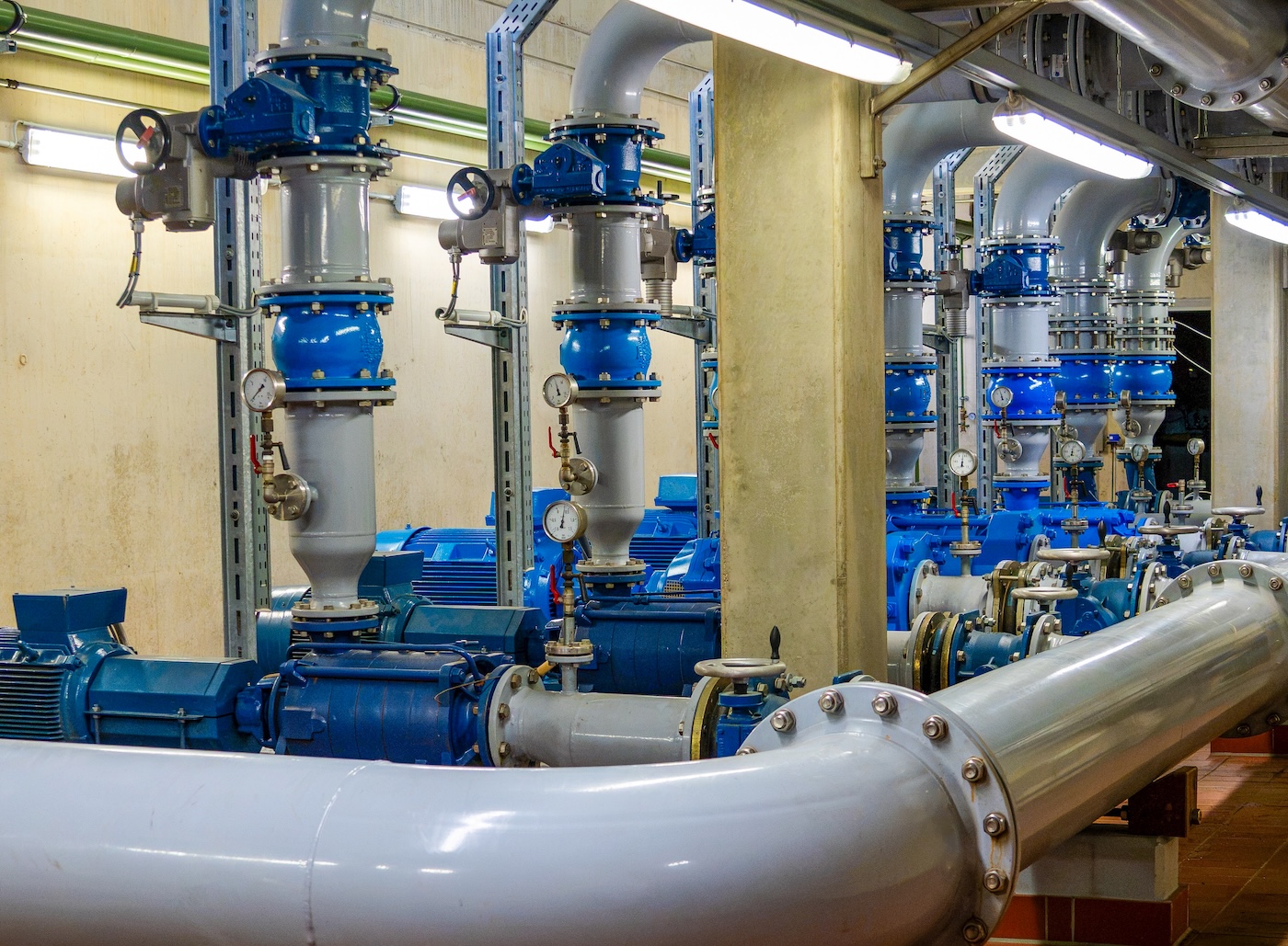 Pumpenanlage im Wasserwerk der Stadtwerke Jülich mit blauen Industriepumpen, Rohrleitungen und Manometern.